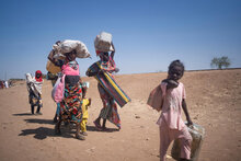 عائلات تحمل أمتعتها عند وصولها إلى جنوب السودان بعد فرارها من القتال في السودان